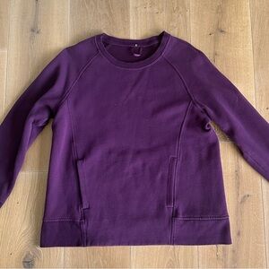 Lululemon purple sweater with pockets on the front.